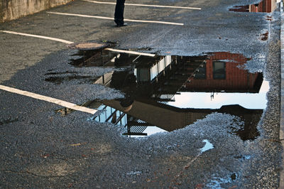 Puddle with reflection of building on road