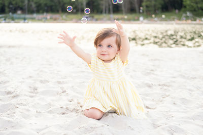 Portrait of cute girl playing with ball at beach