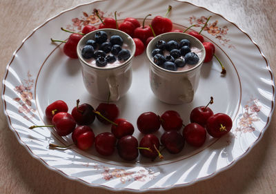 Sweet cherries on a plate with yogurt