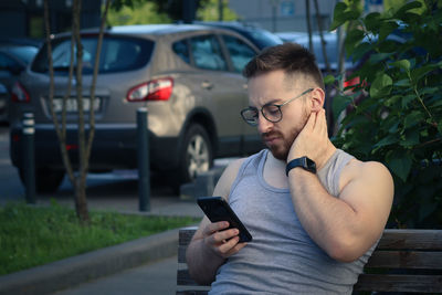 Young man using mobile phone in bus