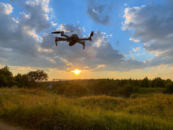 Low angle view of airplane flying against sky during sunset