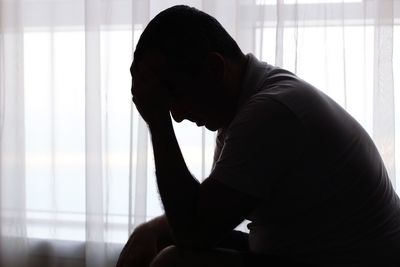 Midsection of man sitting at home