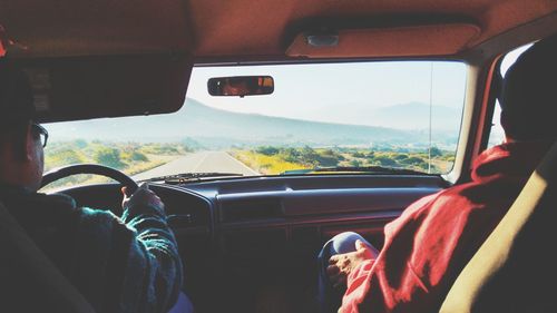 Rear view of friends in car on road