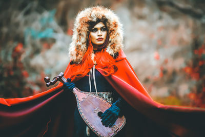 Portrait of mask against orange wall