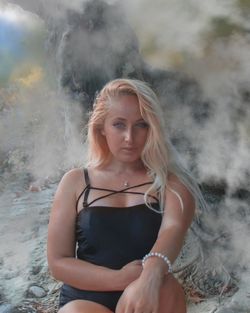 Portrait of beautiful young woman sitting on field