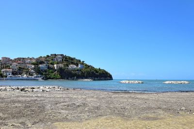Scenic view of beach against clear blue sky