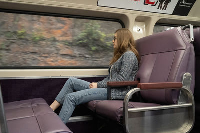 Side view of woman sitting in bus