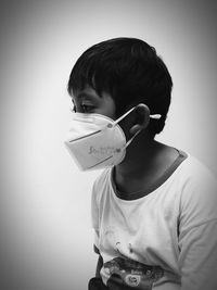 Portrait of boy holding while standing against wall at home