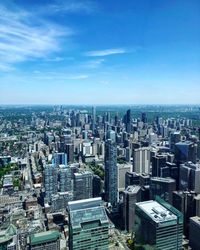 High angle view of modern buildings in city against blue sky