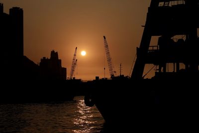 Silhouette buildings against sky during sunset