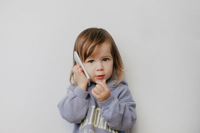 Portrait of young woman against wall