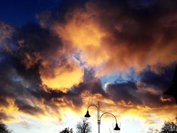 Low angle view of silhouette windmills against sky during sunset