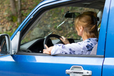 Senior woman sitting in car