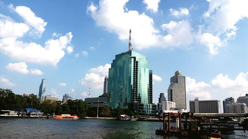 Modern buildings in city against cloudy sky