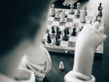 Cropped image of boy playing chess at table