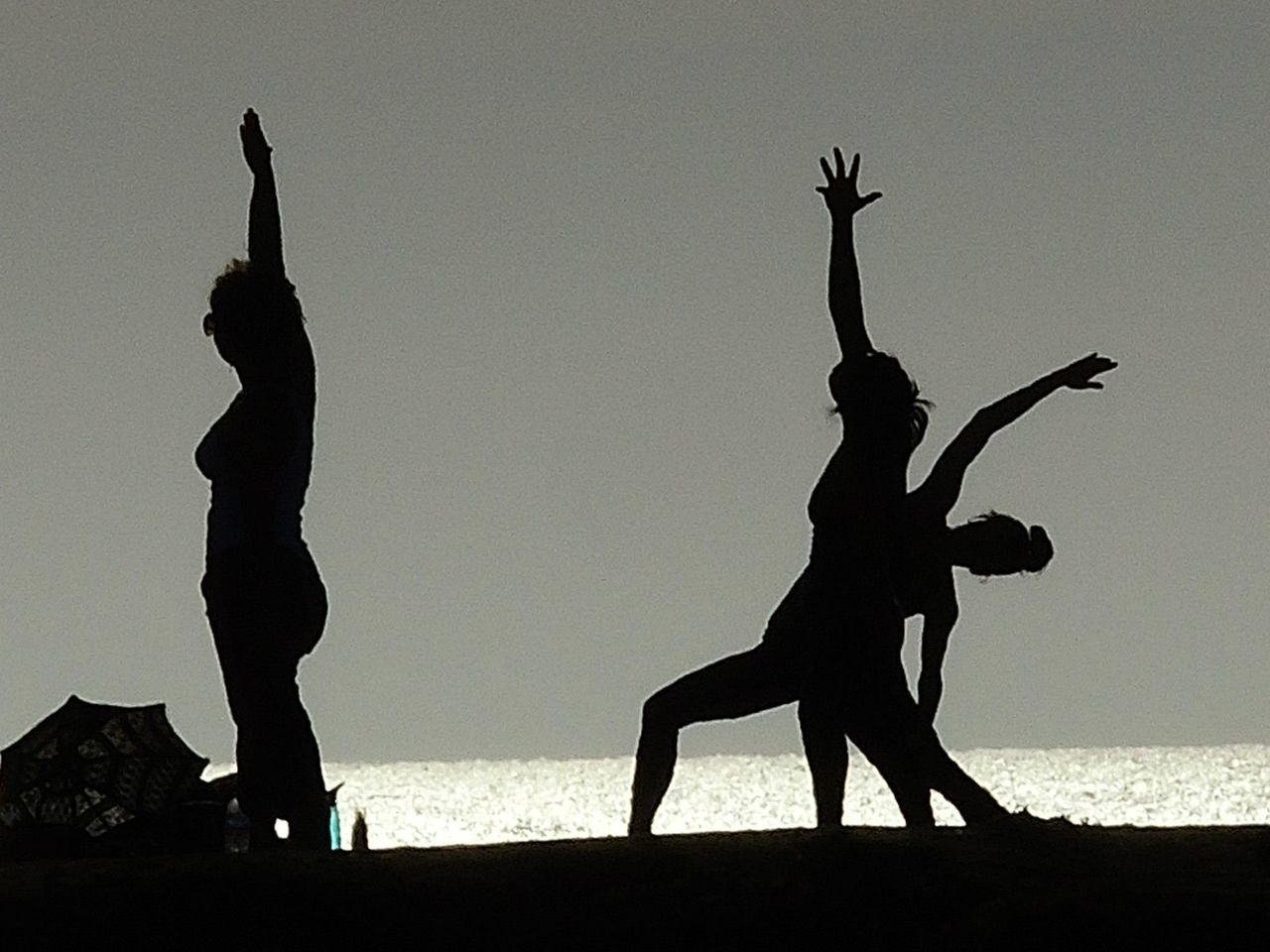 SILHOUETTE PEOPLE ON SHORE AGAINST CLEAR SKY