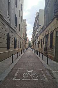 Road amidst buildings against sky in city