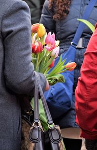 Rear view of people standing by flowering plants