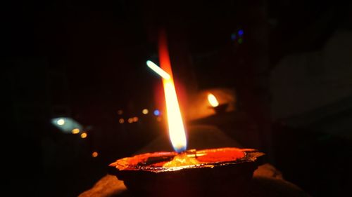 Close-up of lit candle in the dark