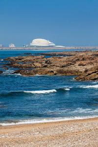 Scenic view of beach against clear blue sky