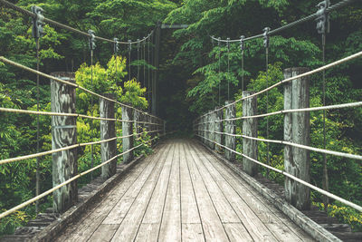 Rear view of man walking on footbridge