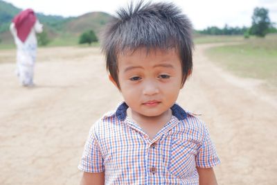 Portrait of cute boy standing on land