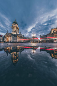 Reflection of illuminated building in water at dusk