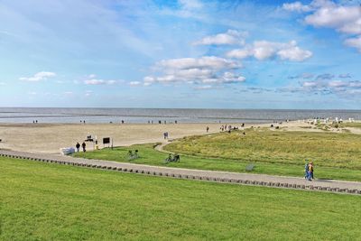 Scenic view of beach with people against sky