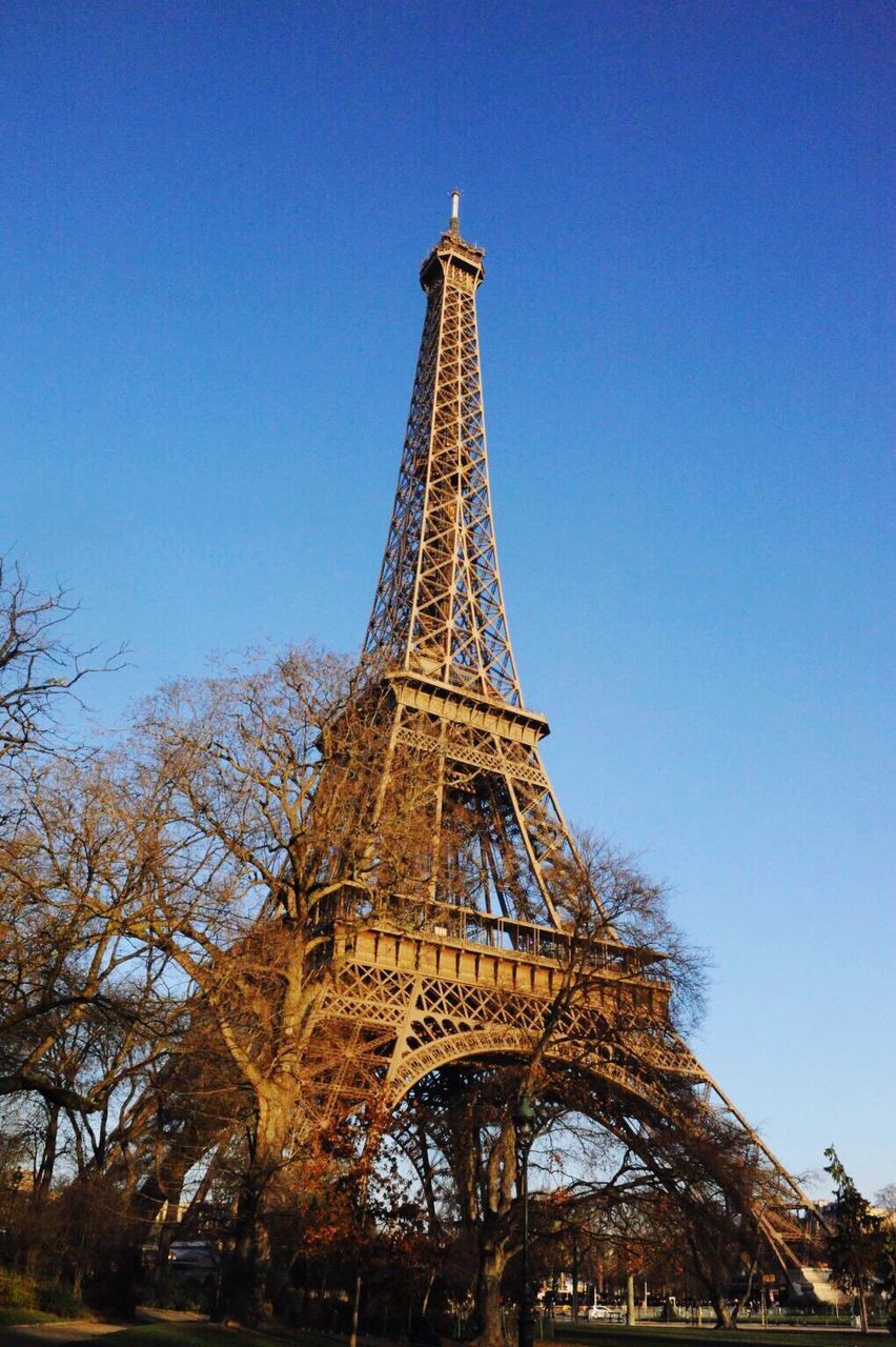 eiffel tower, built structure, architecture, clear sky, tower, famous place, low angle view, international landmark, travel destinations, tall - high, culture, tree, tourism, metal, capital cities, travel, history, blue, architectural feature, metallic