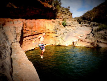 Boy jumping in river