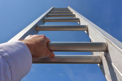 Hands climbing a ladder to the sky