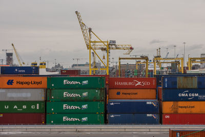 Stack of cargo containers at harbor against sky