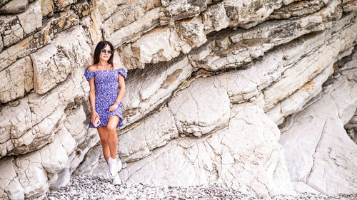 Full length of woman standing against rock formations