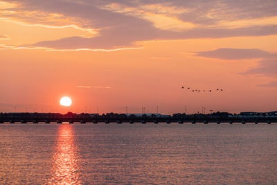 Scenic view of sea against romantic sky at sunset