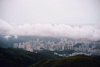 View of cityscape against cloudy sky