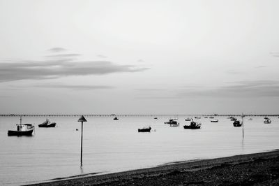 Boats in calm sea against sky