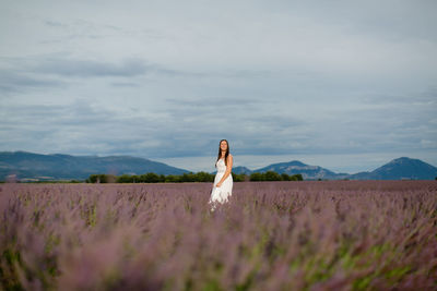 Woman standing on field against sky