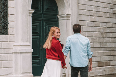 Friends standing against building