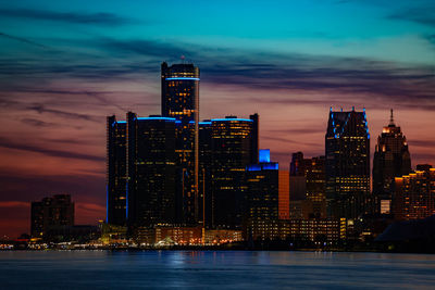 Illuminated buildings in city against sky at night