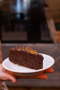 Cropped hand holding cake