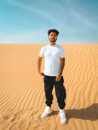 Rear view of man standing at desert against clear sky