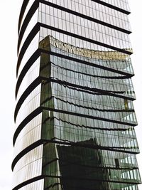 Low angle view of glass building against clear sky