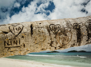 Text on beach by sea against sky