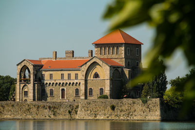 Castle by trees against clear sky