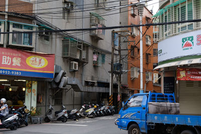 Cars on road by buildings in city