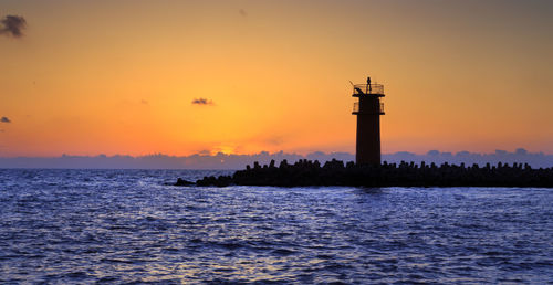 Scenic view of sea against orange sky