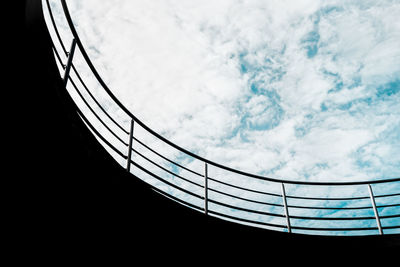 Low angle view of railing against cloudy sky