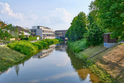 River amidst trees and buildings against sky