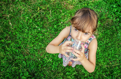 High angle view of young woman sitting on grassy field