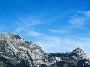 Low angle view of mountain against blue sky